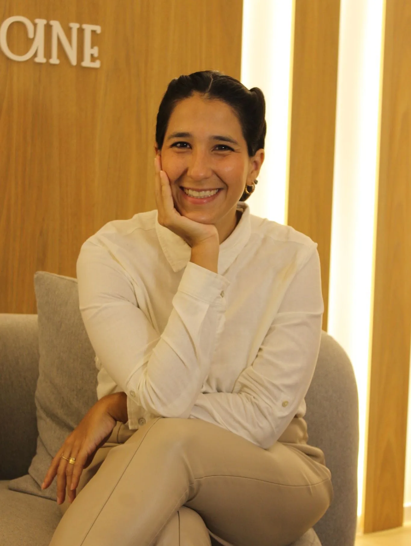 Dra. Luisa Mattos sorrindo, sentada no consultório